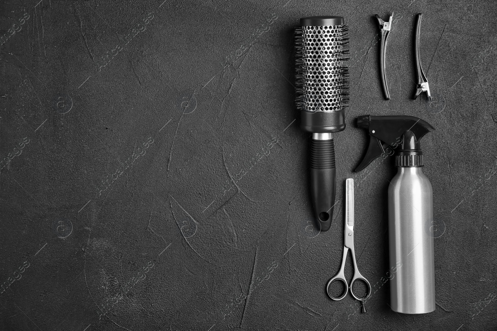 Photo of Flat lay composition with professional hairdresser tools on black background