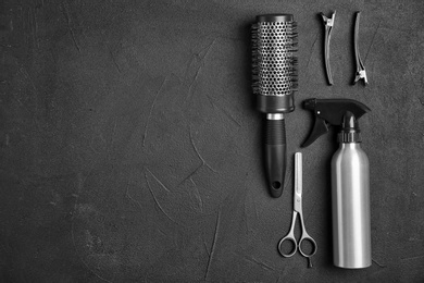 Photo of Flat lay composition with professional hairdresser tools on black background
