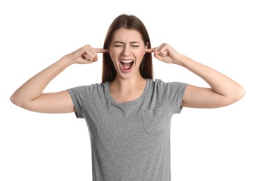 Emotional young woman covering her ears with fingers on white background