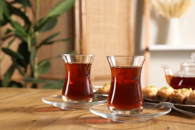 Photo of Traditional Turkish tea in glasses on wooden table