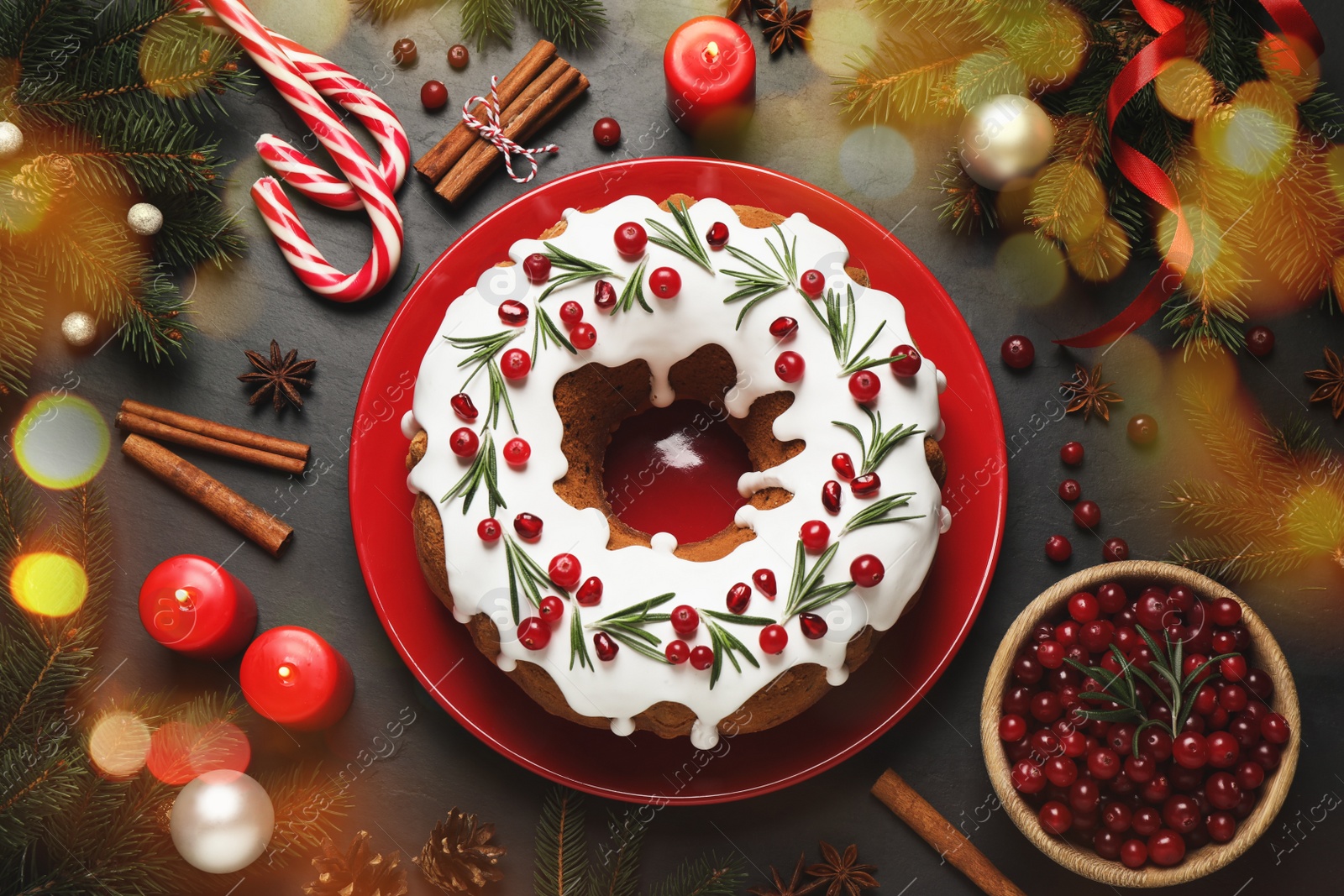Image of Flat lay composition with traditional Christmas cake and decorations on dark grey table. Bokeh effect