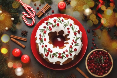 Image of Flat lay composition with traditional Christmas cake and decorations on dark grey table. Bokeh effect