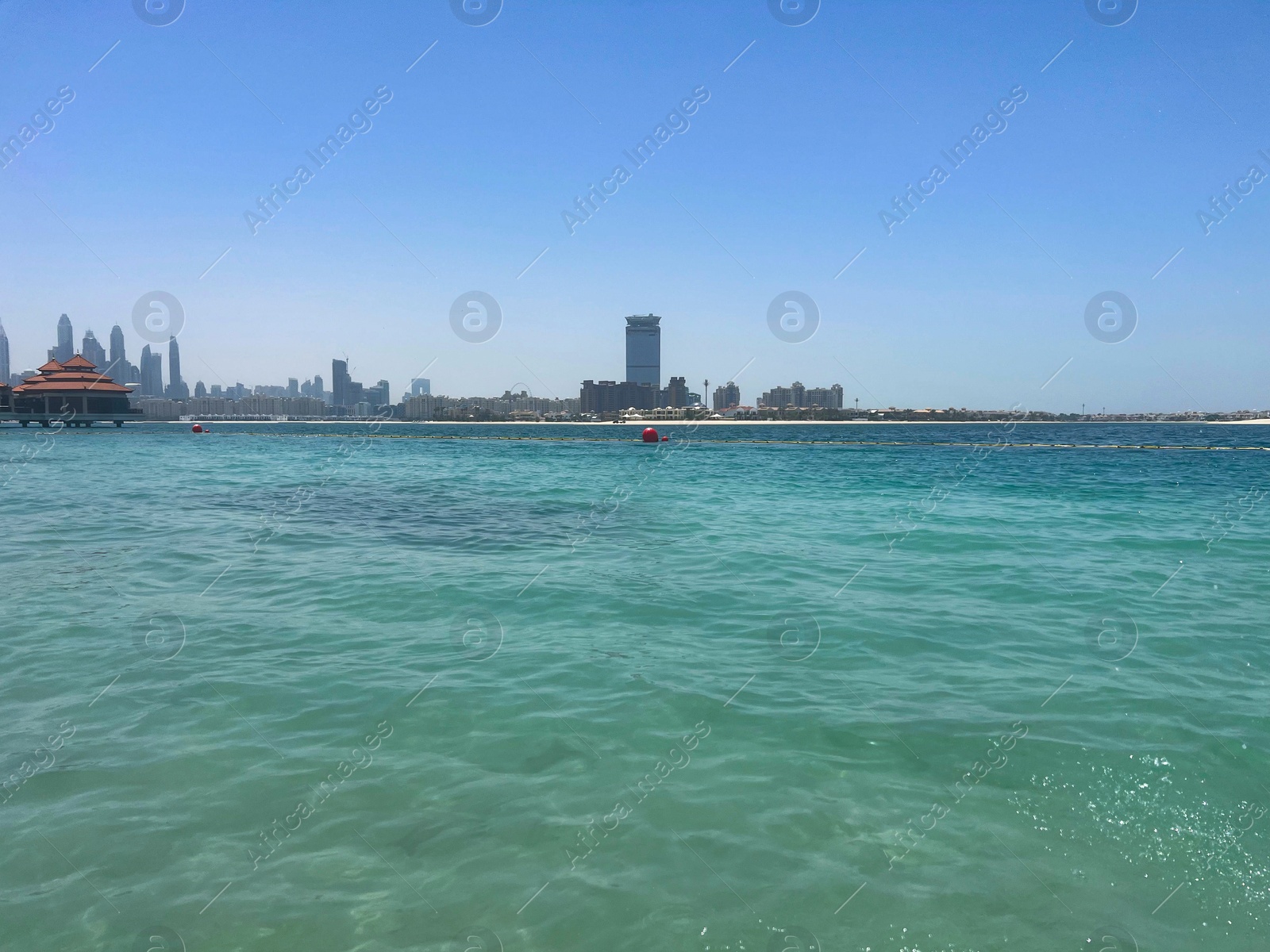 Photo of Picturesque view of calm sea and city under blue sky