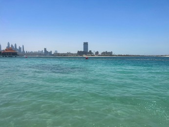 Picturesque view of calm sea and city under blue sky