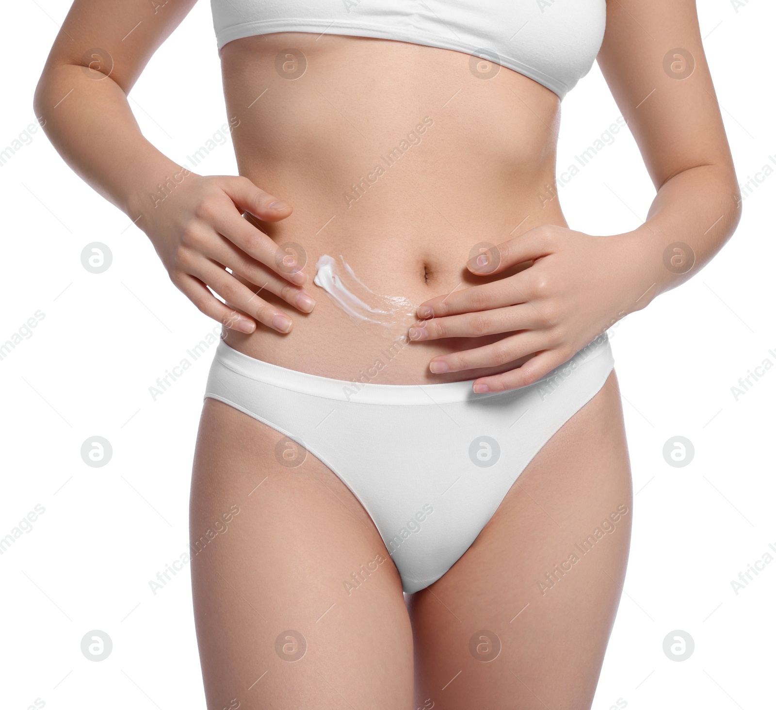 Photo of Young woman with body cream smear on belly against white background, closeup