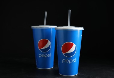 Photo of MYKOLAIV, UKRAINE - JUNE 08, 2021: Paper Pepsi cups on black background