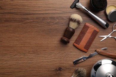 Photo of Moustache and beard styling tools on wooden background, flat lay. Space for text