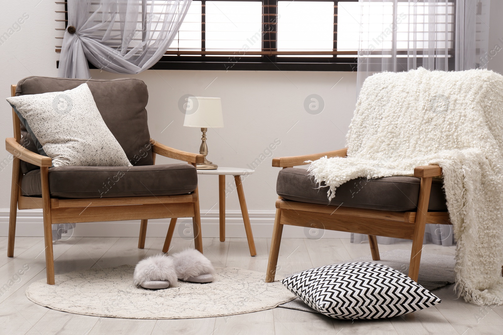 Photo of Cozy interior with armchairs, pillows and plaid near window