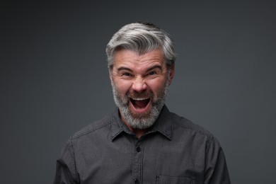 Photo of Personality concept. Emotional man screaming on dark grey background