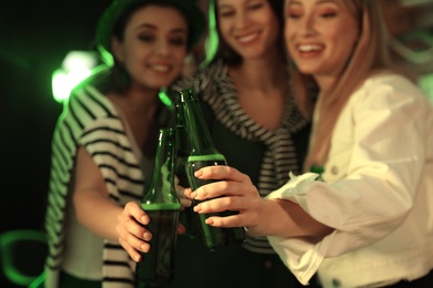 Women with beer celebrating St Patrick's day in pub, focus on hands