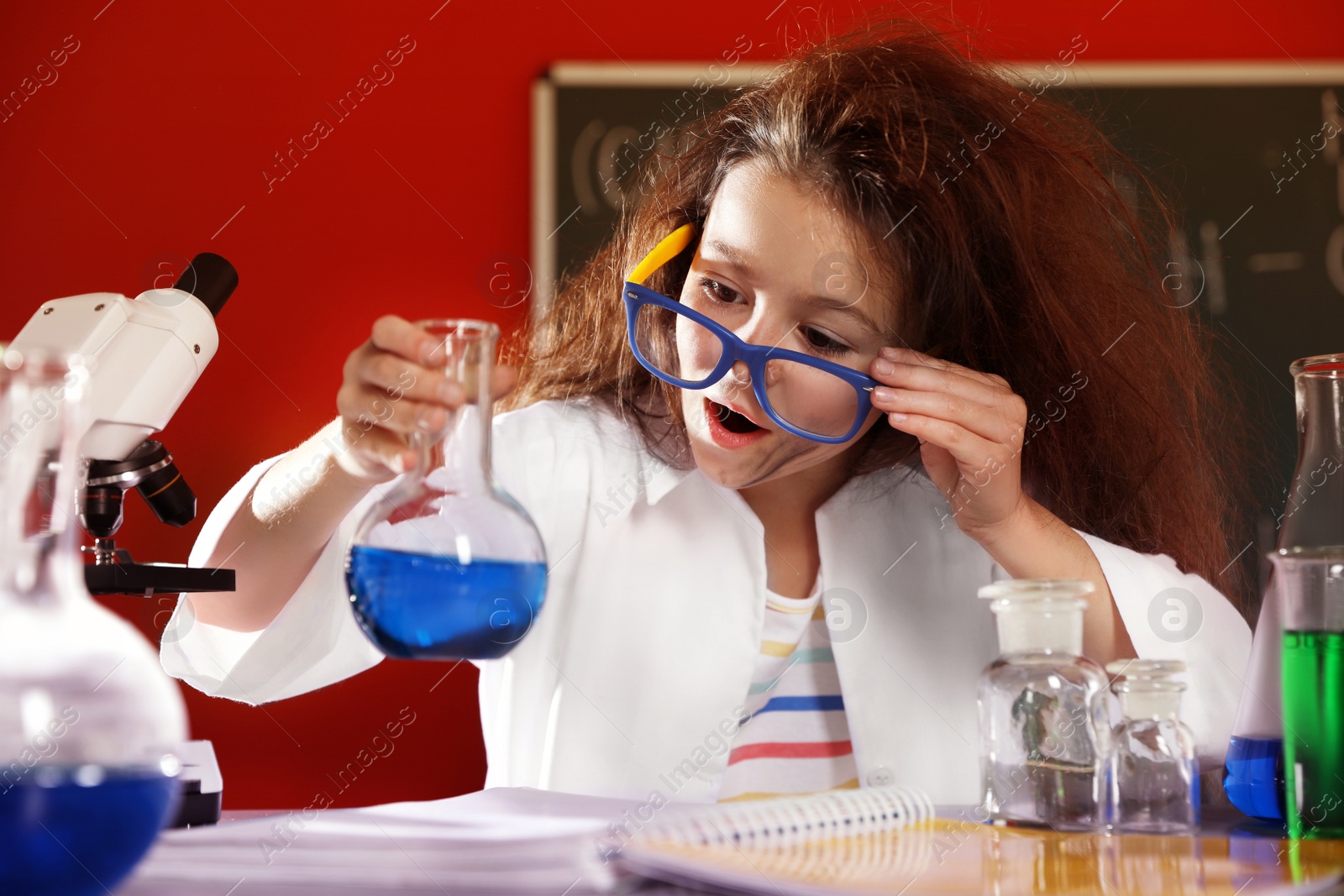 Photo of Child doing chemical research in laboratory. Dangerous experiment