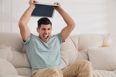 Photo of Emotional man with modern laptop at home