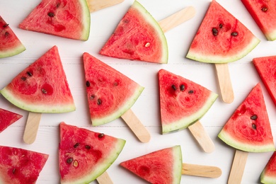 Photo of Slices of ripe watermelon on white wooden table, flat lay