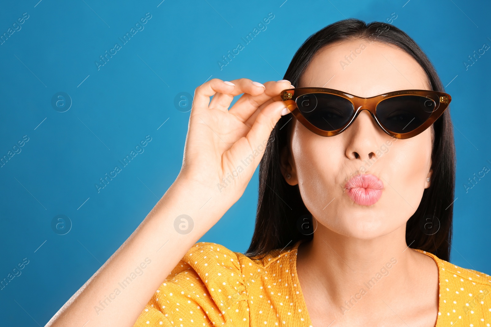 Photo of Beautiful woman wearing sunglasses on blue background