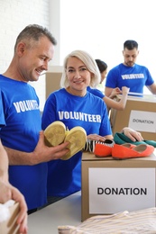 Photo of Team of volunteers collecting donations in boxes indoors