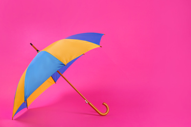 Photo of Colorful umbrella on pink background. Space for text