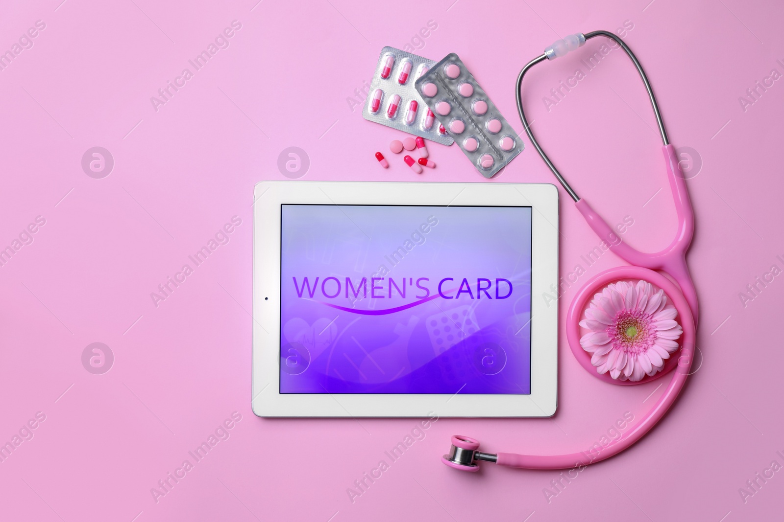 Photo of Tablet, flower, stethoscope and pills on pink background, flat lay. Gynecological care