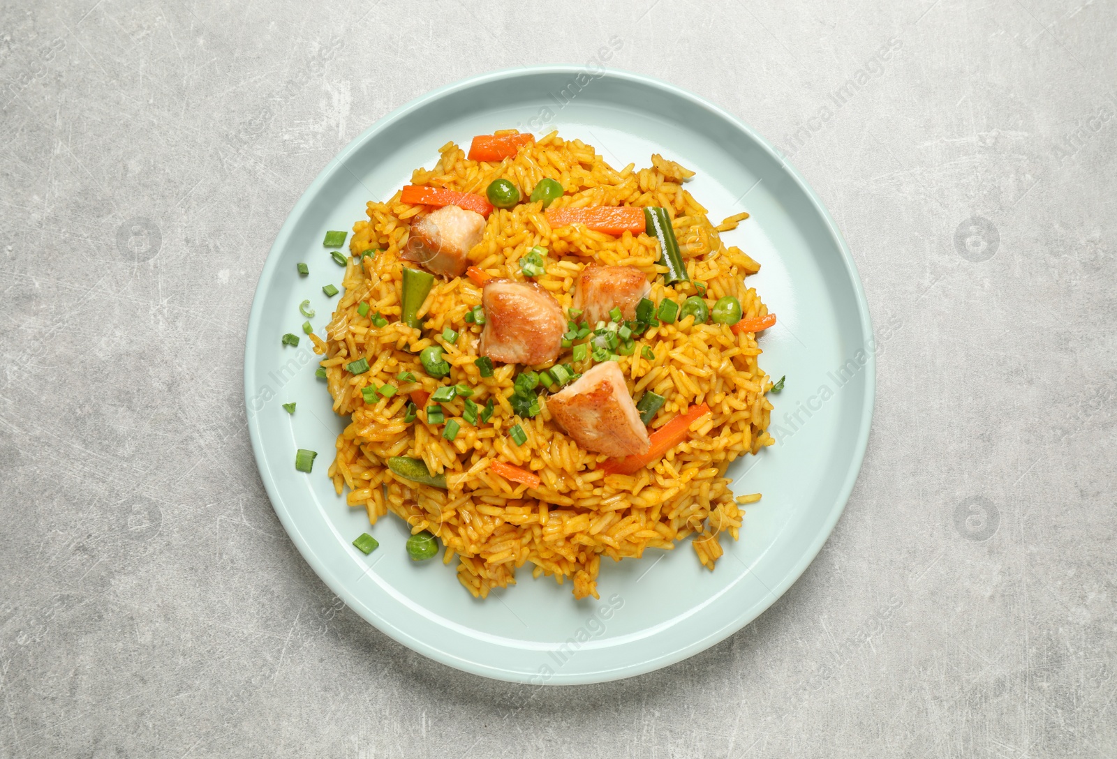 Photo of Delicious rice pilaf with vegetables on light grey table, top view