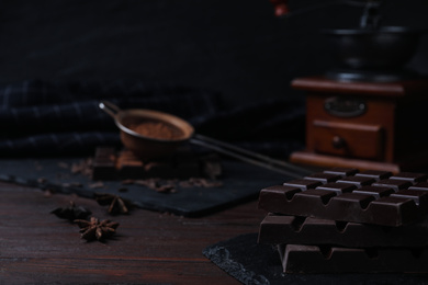 Tasty dark chocolate bars on wooden table