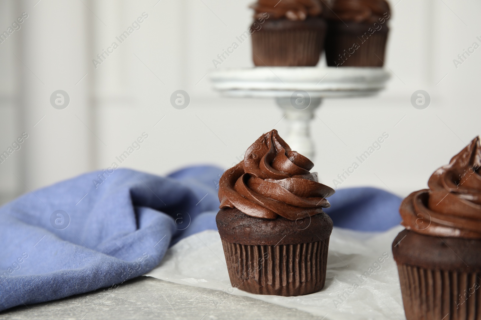 Photo of Delicious chocolate cupcake with cream on grey table. Space for text