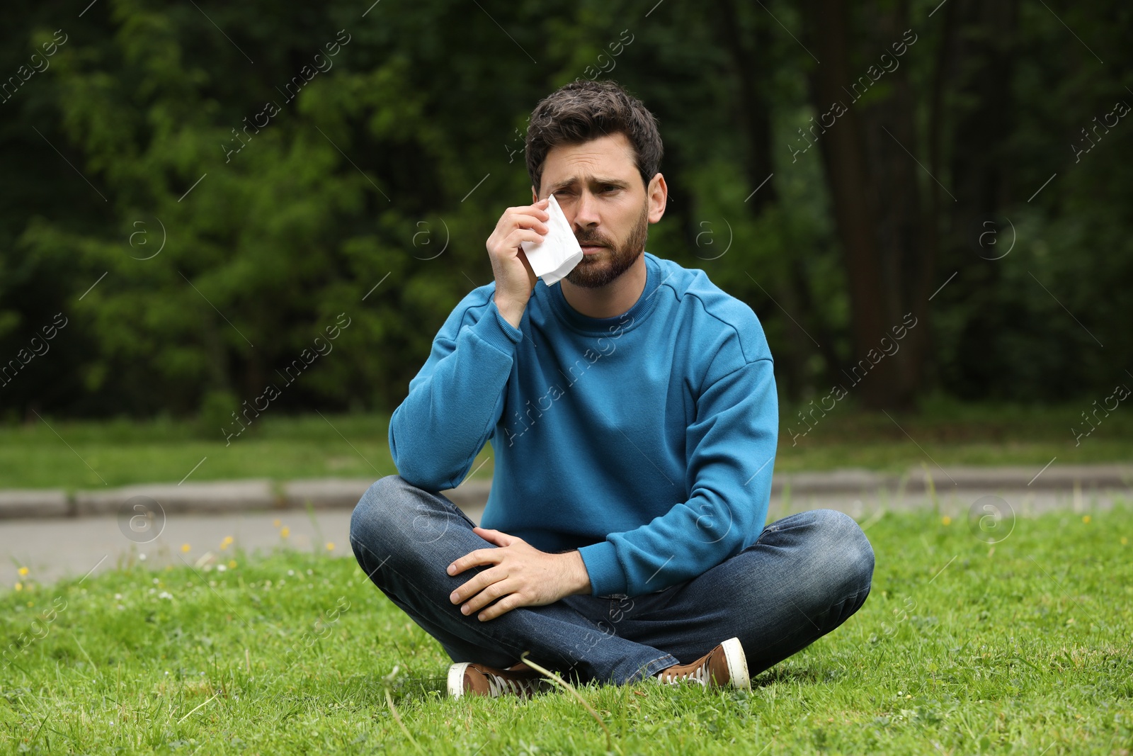 Photo of Man suffering from seasonal spring allergy on green grass in park