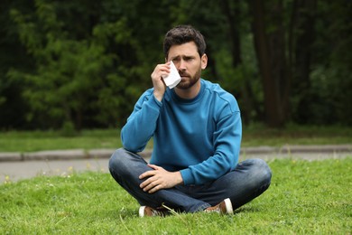 Photo of Man suffering from seasonal spring allergy on green grass in park