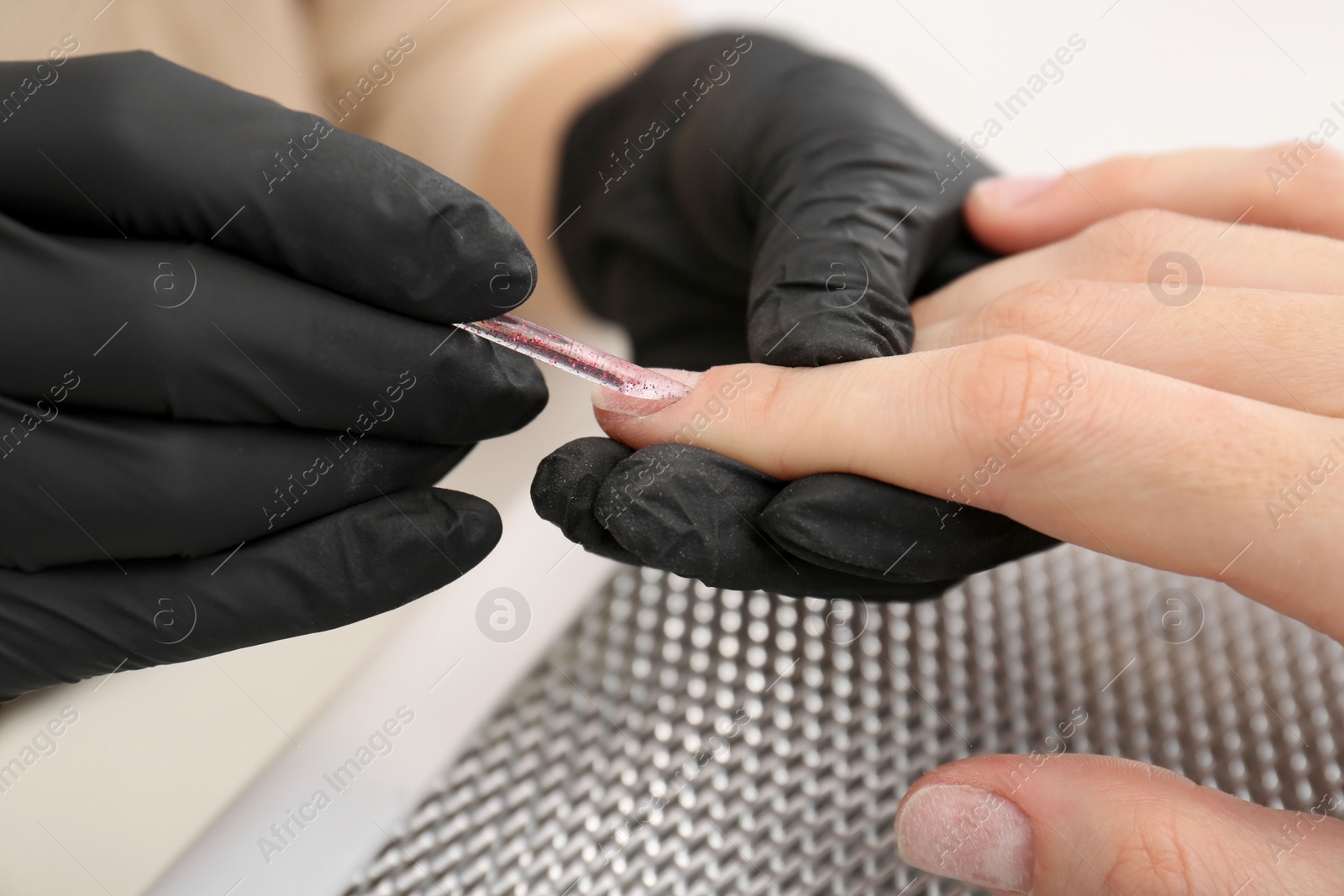 Photo of Professional manicurist working with client, closeup view