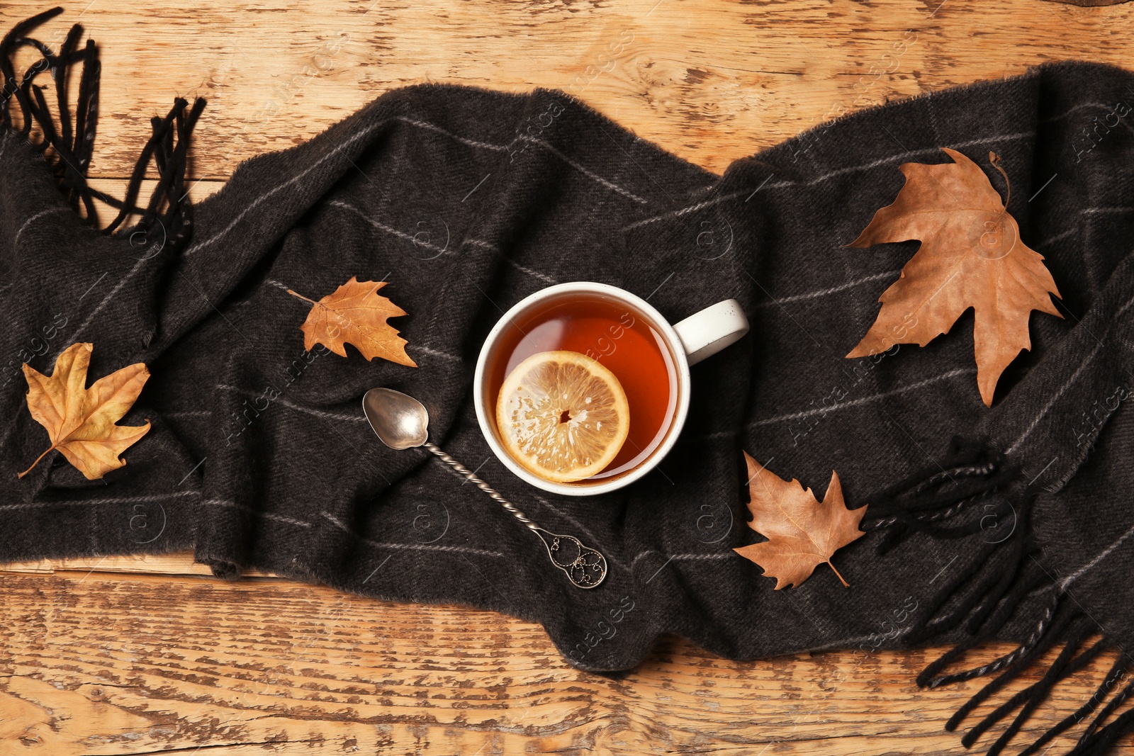 Photo of Flat lay composition with hot cozy drink, scarf and autumn leaves on wooden background