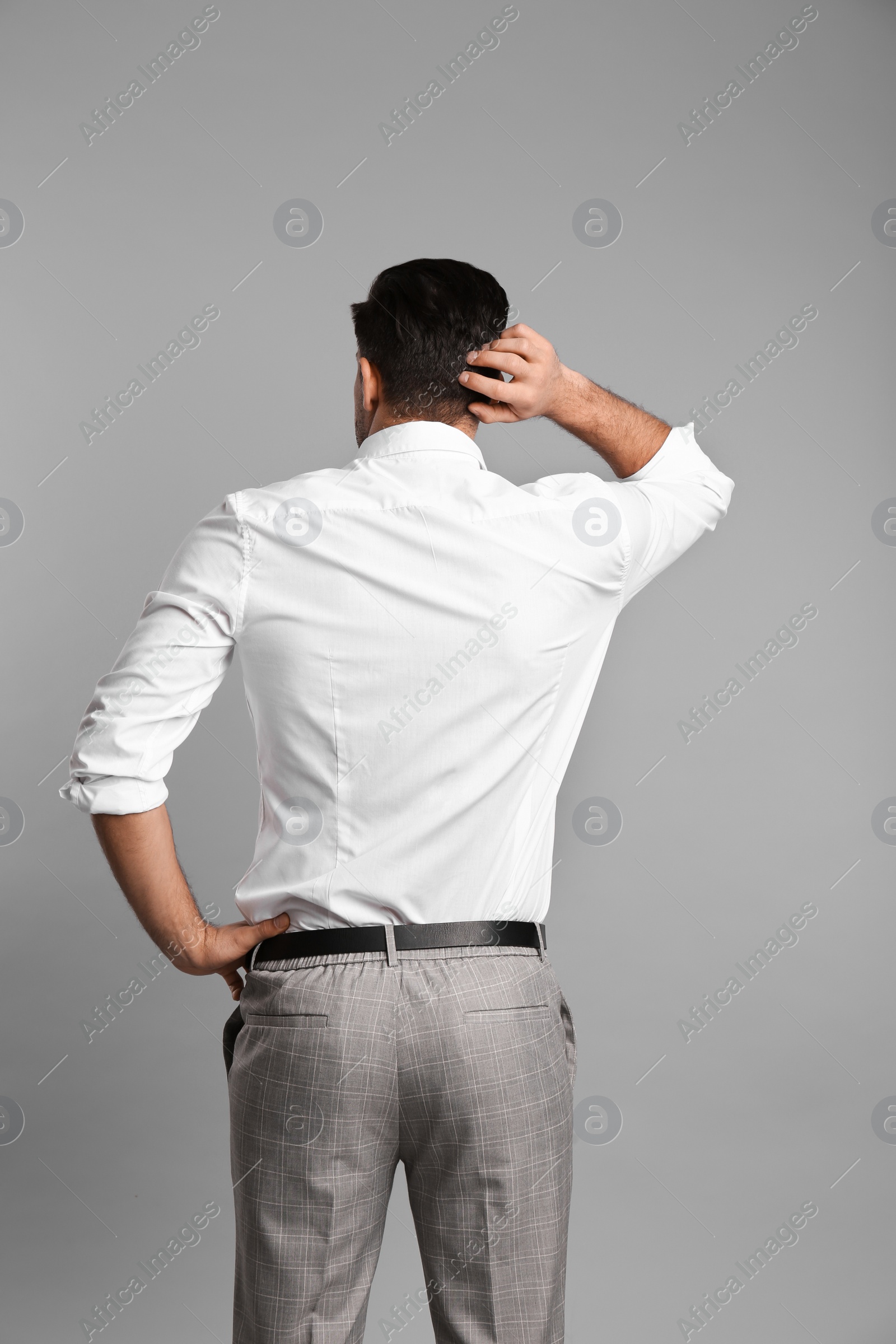 Photo of Businessman in formal clothes on grey background, back view