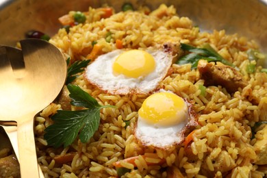 Tasty rice with meat, eggs and vegetables in frying pan, closeup