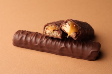 Photo of Sweet tasty chocolate bars with caramel on beige background