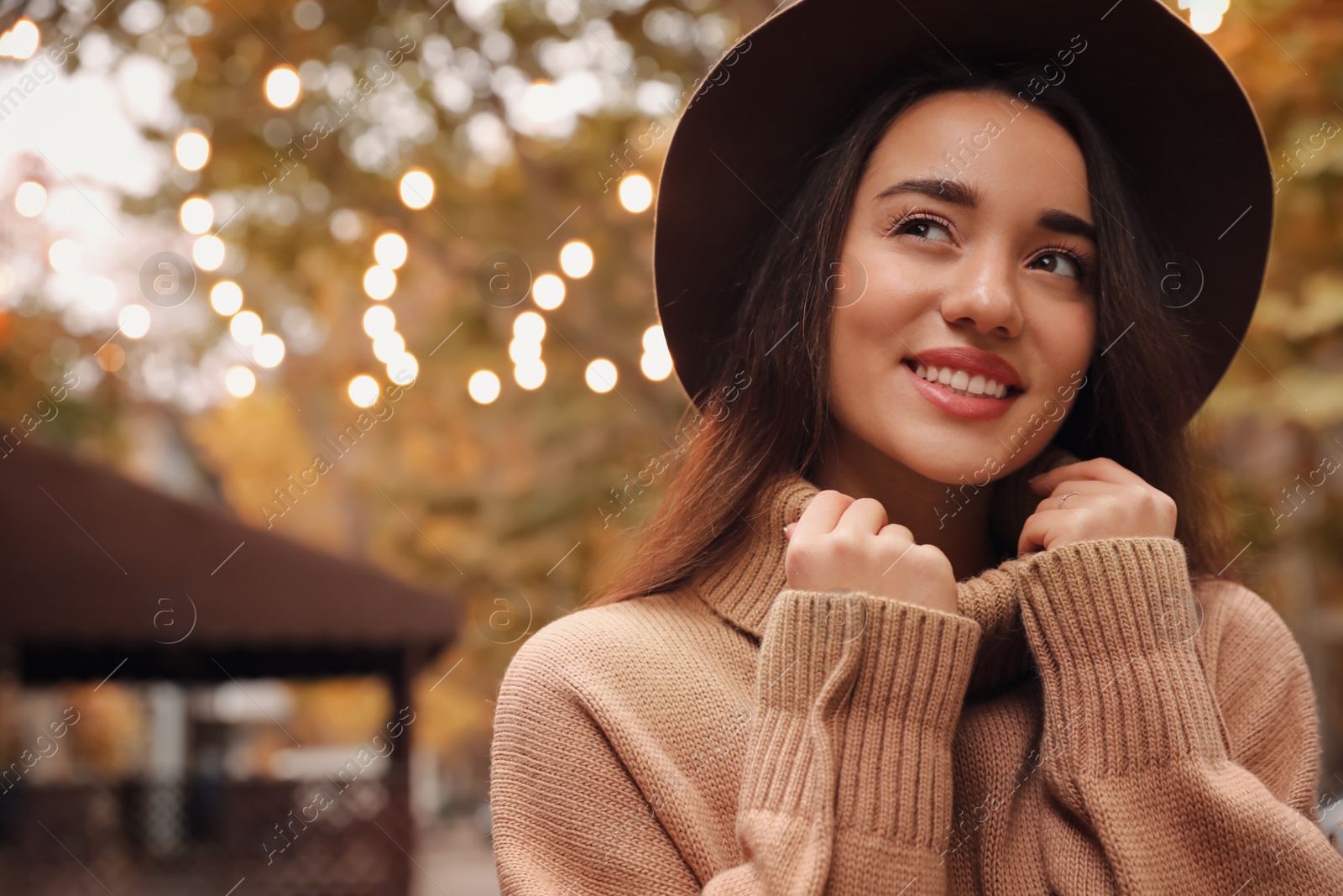 Photo of Young woman wearing stylish clothes outdoors, space for text. Autumn look