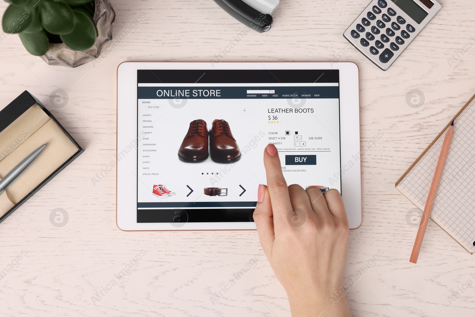 Photo of Woman with tablet shopping online at white wooden table, top view