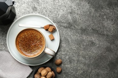 Photo of Coffee with nutmegs on grey table, flat lay. Space for text