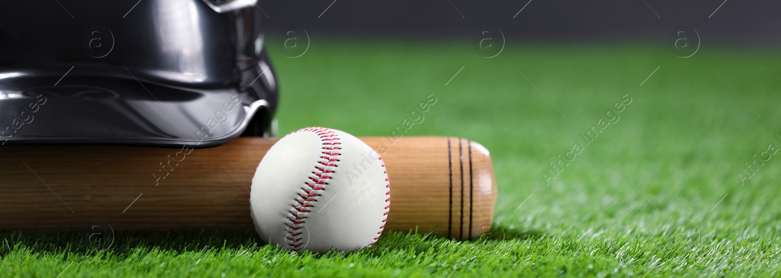 Image of Baseball bat, batting helmet and ball on green grass, space for text. Banner design