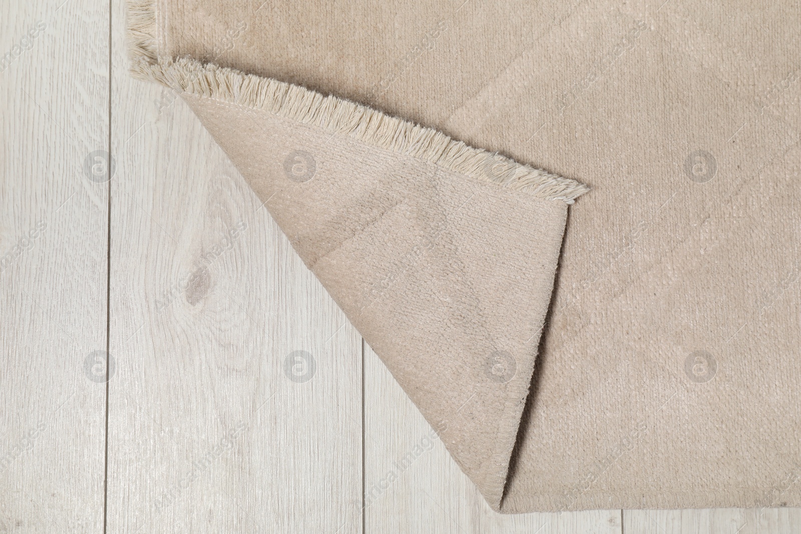 Photo of Soft beige carpet on white laminated floor indoors, top view. Space for text