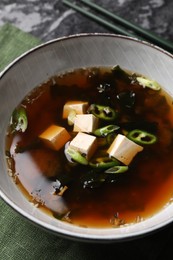 Photo of Bowl of delicious miso soup with tofu on table