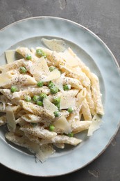 Photo of Delicious pasta with green peas, cheese and creamy sauce on grey table, top view