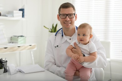 Pediatrician with cute little baby in clinic