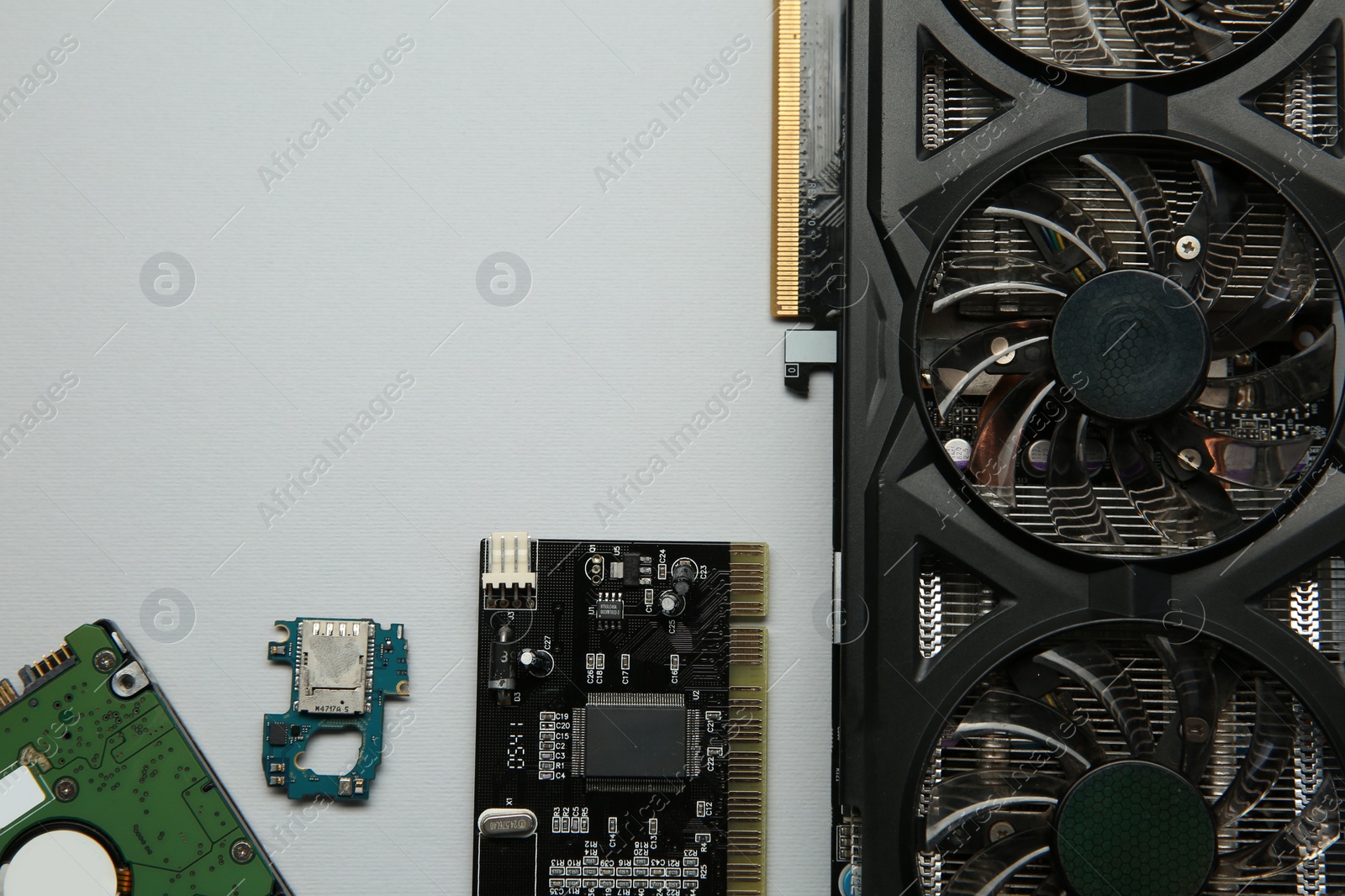 Photo of Graphics card and other computer hardware on light background, flat lay. Space for text