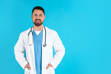 Photo of Mature doctor with stethoscope on blue background, space for text