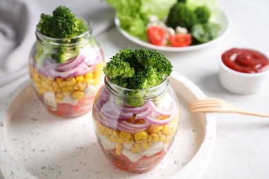 Photo of Healthy salad in glass jars on light table