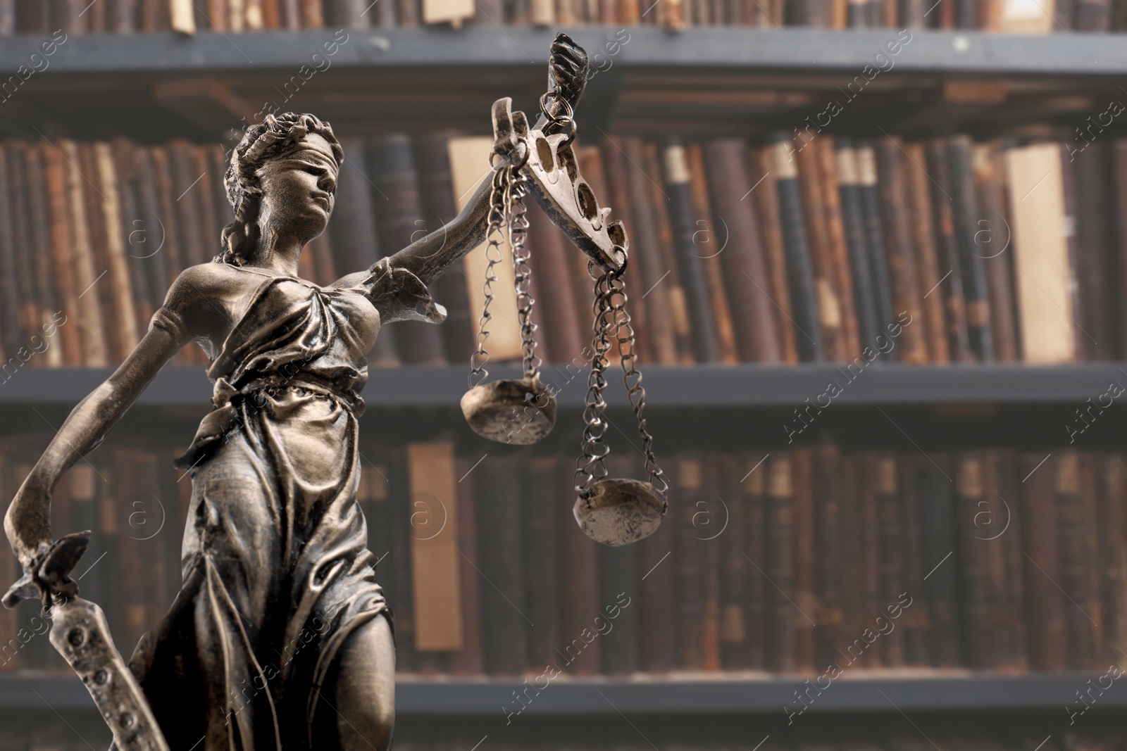 Image of Law and wisdom. Statue of Lady Justice near shelves with books, space for text