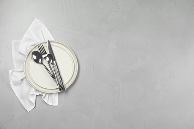 Photo of Stylish setting with elegant cutlery on grey table, top view. Space for text