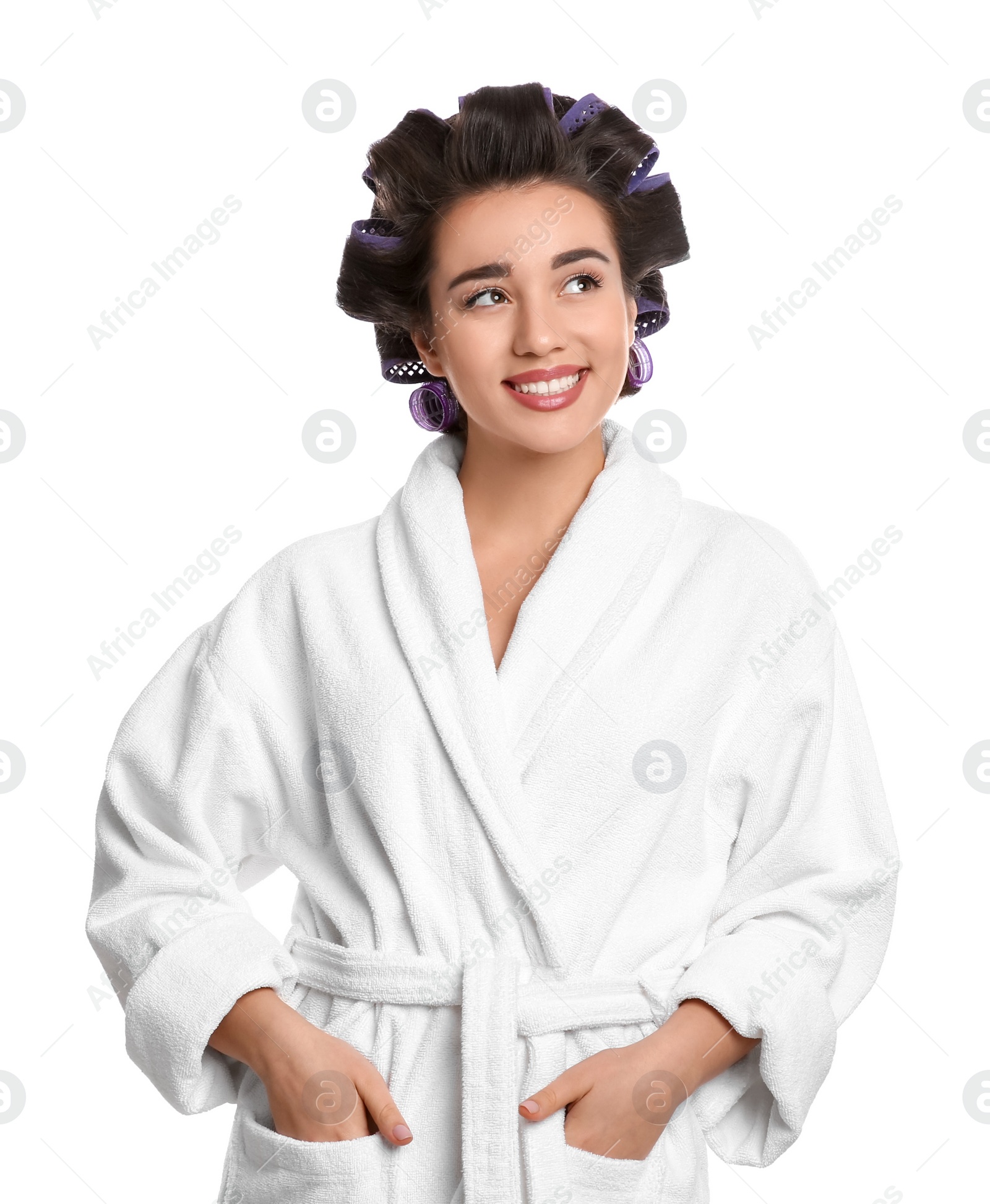 Photo of Happy young woman in bathrobe with hair curlers on white background