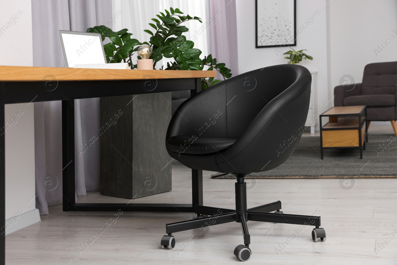 Photo of Comfortable office chair near desk in modern workplace