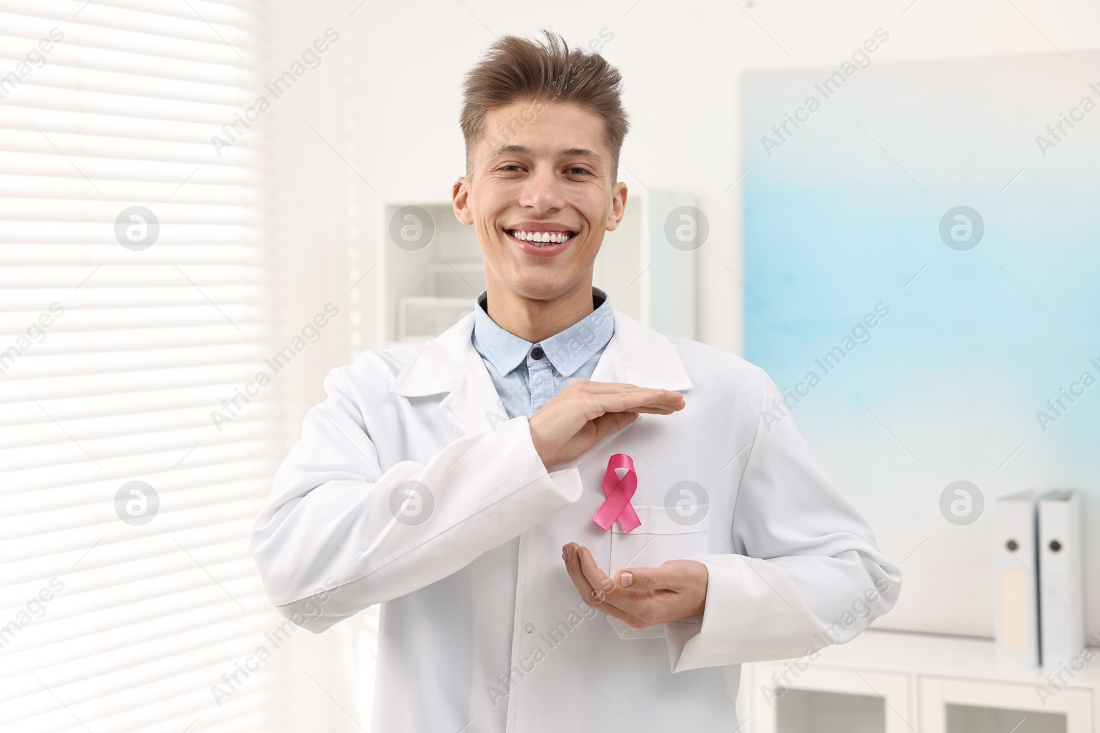 Photo of Mammologist with pink ribbon in hospital. Breast cancer awareness