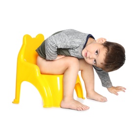 Photo of Portrait of little boy sitting on potty against white background