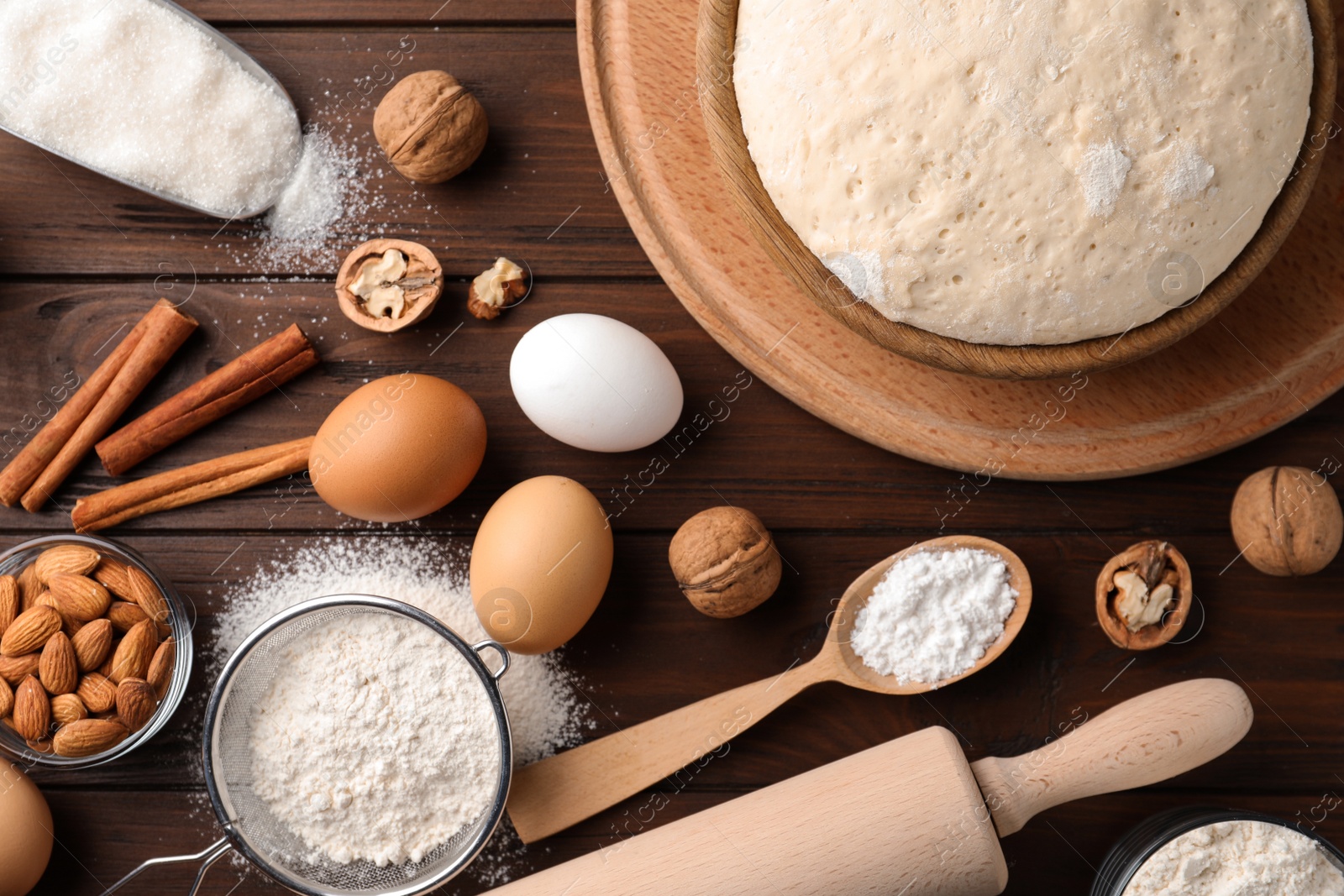 Photo of Dough and ingredients for pastries on wooden table, flat lay