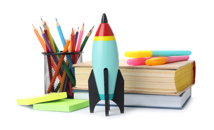 Bright toy rockets and school supplies on white background